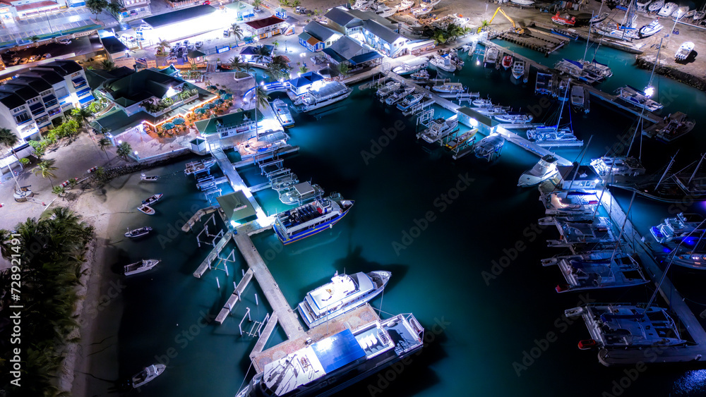Beautiful scenic aerial night view of the Caribbean island of St Maarten. Boats and yacht docked at night.