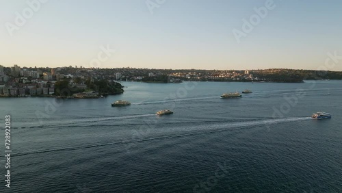 Many boats sailing through Sydney Harbour at sunset photo