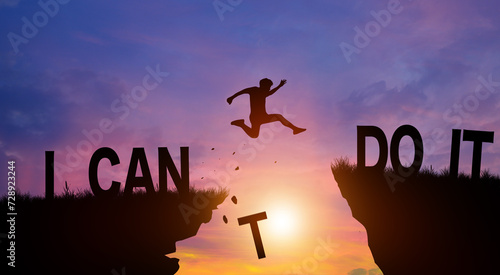 Silhouette man jumping over I can do it wording on cliffs with cloud sky and sunrise. Never give up, Good mindset, and Successful achievement Concept. photo