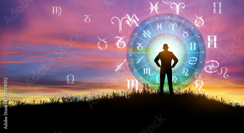 Fototapeta Naklejka Na Ścianę i Meble -  Astrological zodiac signs inside of horoscope circle. Illustration of Man silhouette consulting the Sun over the zodiac wheel and Sunrise background. The power of the universe concept.