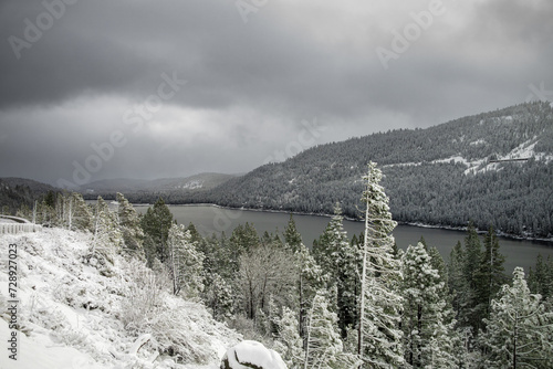 Donner Lake from Highway 80 with snow covered trees and mountains during a winter storm