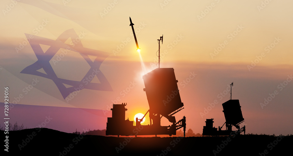 Israel's Iron Dome air defense missile launches. The missiles are aimed at the sky at sunset with Israel flag.