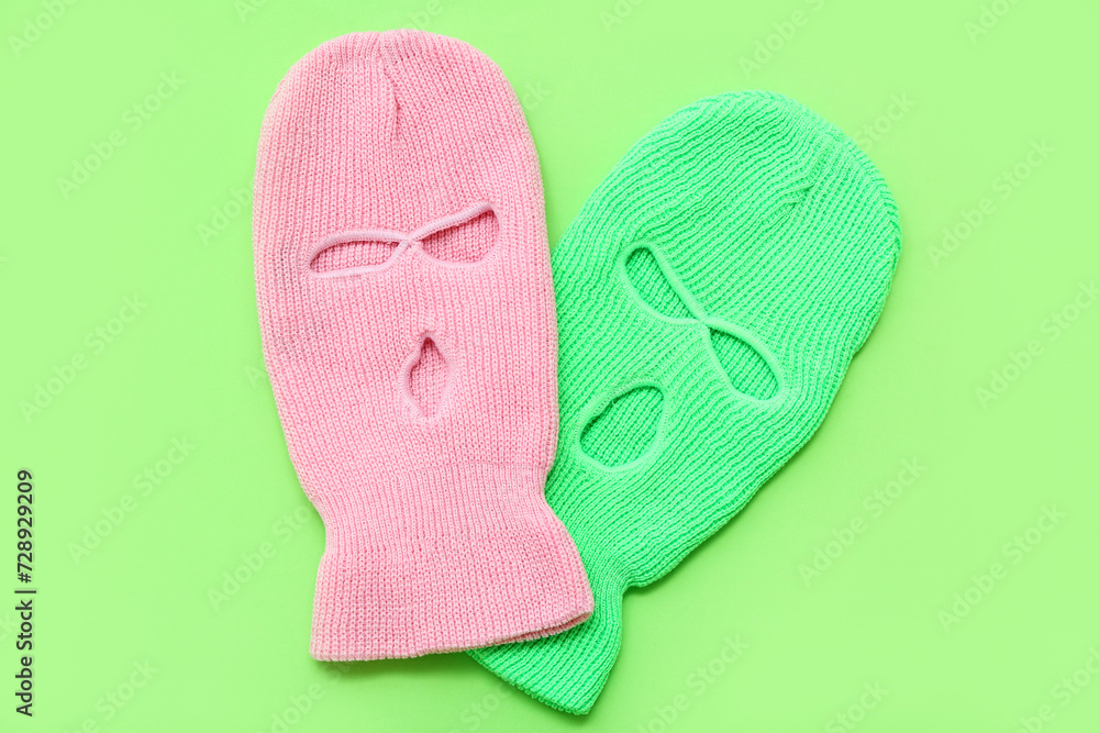 Fotografie Stylish balaclavas on green background