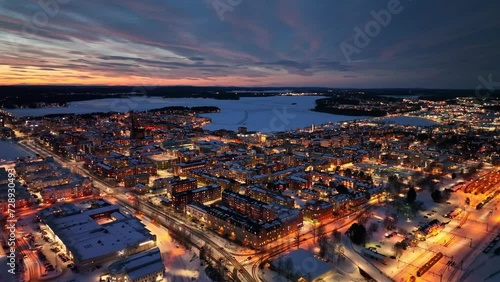 Luleå city at dusk with city lights reflecting on snowy streets and frozen waterways, winter season, aerial view photo