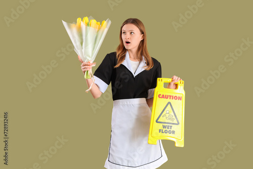 Young chambermaid with bouq...