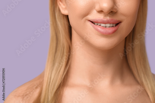 Smiling young woman with beautiful lips on lilac background  closeup