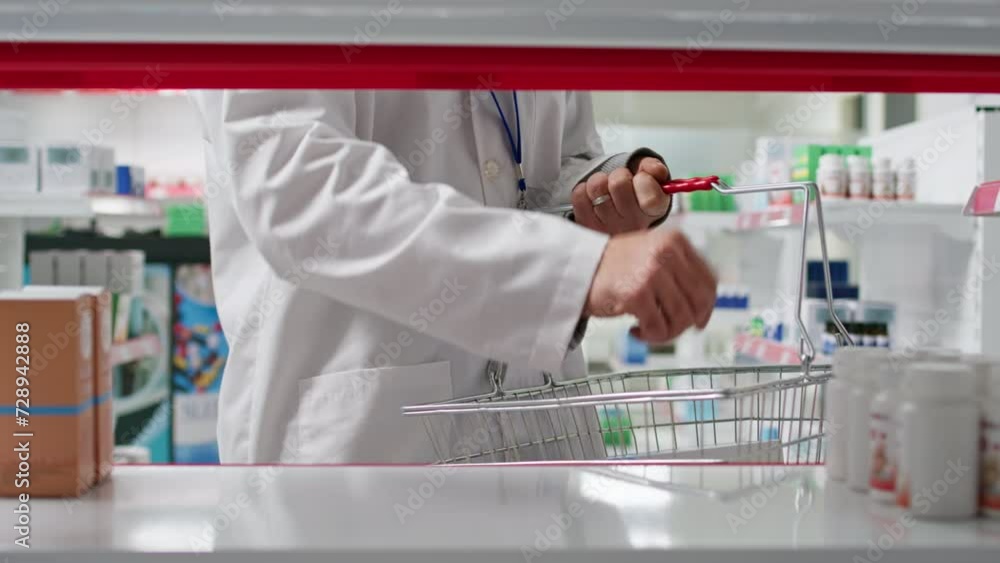 POV of pharmacist putting products from shelves in the basket, reorganizing medicaments based on types and uses. Healthcare worker taking off boxes of pharmaceuticals from racks. Tripod shot. POV of pharmacist putting products from shelves in the basket, reorganizing medicaments based on types and uses. Healthcare worker taking off boxes of pharmaceuticals from racks. Tripod shot.