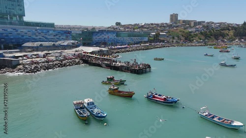 Fishing Boats Moored Off Pier Beside Muelle At San Antonio Port In Chile. Aerial Push Forward  photo