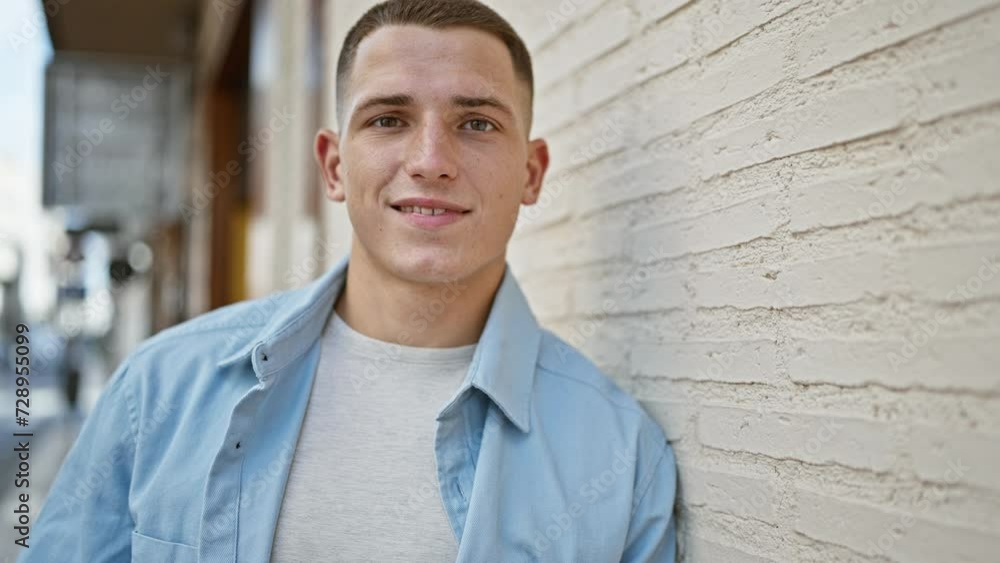 Handsome young man leaning on a white brick urban wall, portraying casual style and relaxed confidence in an outdoor city setting. Handsome young man leaning on a white brick urban wall, portraying casual style and relaxed confidence in an outdoor city setting.