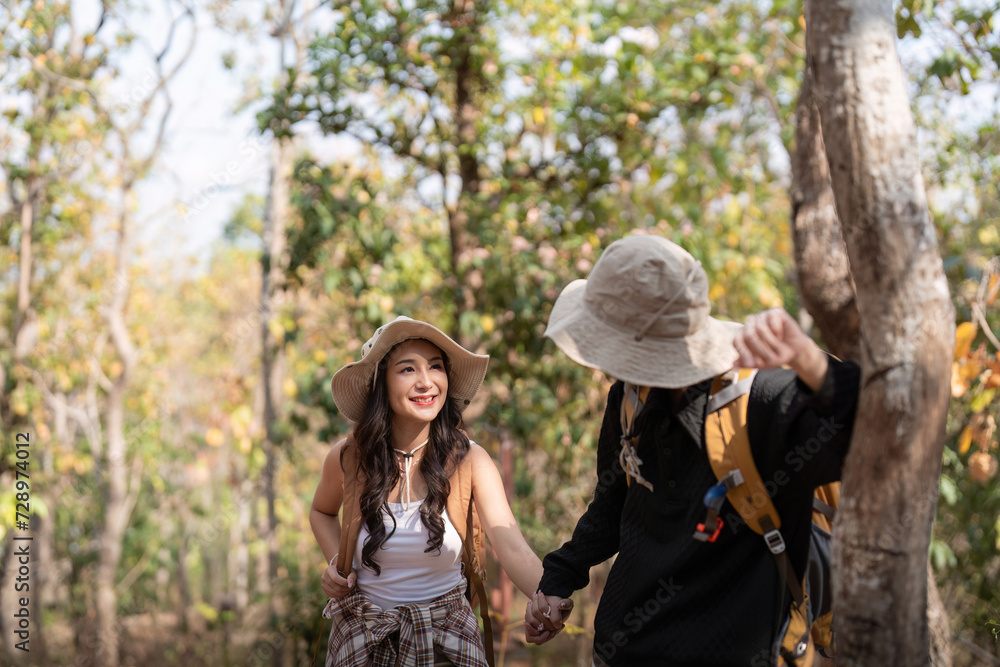Cheerful romantic lesbian couple traveler with backpack on their backs go hiking through the forest in the mountains in summer Cheerful romantic lesbian couple traveler with backpack on their backs go hiking through the forest in the mountains in summer