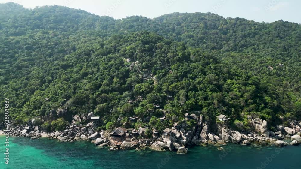 Mango Bay in Ko Tao Island Thailand seaside resort with rocky shoreline cabins, Aerial approach shot Mango Bay in Ko Tao Island Thailand seaside resort with rocky shoreline cabins, Aerial approach shot