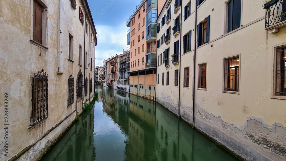 The picturesque water channel of San Massimo beautifully winds through the heart of the historic city of Padua, Italy, gracefully passing by charming residential houses. City in Veneto, Northern Italy