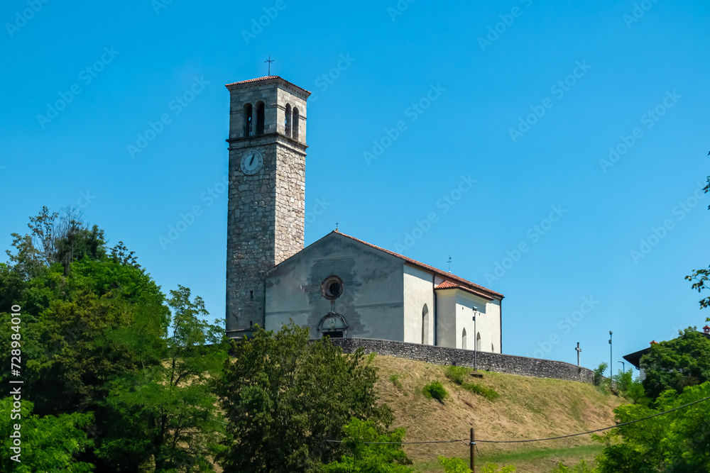Scenic view of church La chiesa di San Stefano near Castle of Ragogna (Ruvigne) in Valeriano (Pinzano al Tagliamento), Friuli Venezia Giulia, Italy. Catholic landmark on hill with blue sky background