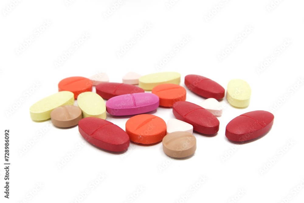 Detailed photos of oval, round and triangular shaped tablets in various colors: red, orange, yellow and cream. The photo was taken on a white background Detailed photos of oval, round and triangular shaped tablets in various colors: red, orange, yellow and cream. The photo was taken on a white background