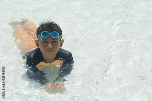 Boy playing in water using swimming goggles