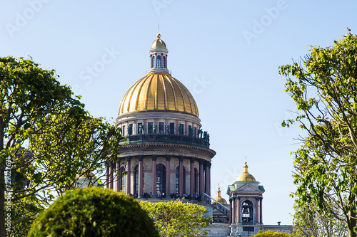 Famous St. Isaac Cathedral on summer day. Green trees and golden domes of cathedral on a sunny day. Saint Petersburg. Russia