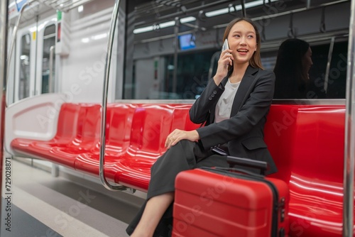 Young Asian Businesswoman Using Phone On The Public Skytrain