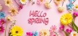 Colorful spring flower composition encircles the text 'hello spring' on a gradient pink background