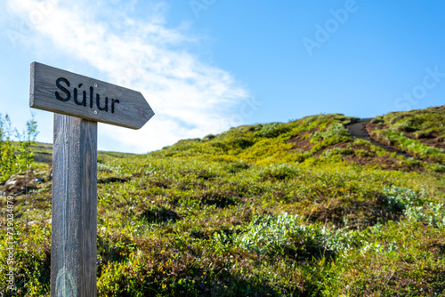 Signpost on the top of a mountain with a blue sky in the background