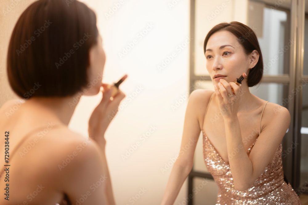 ドレスを着てメイク直しをする女性 ドレスを着てメイク直しをする女性