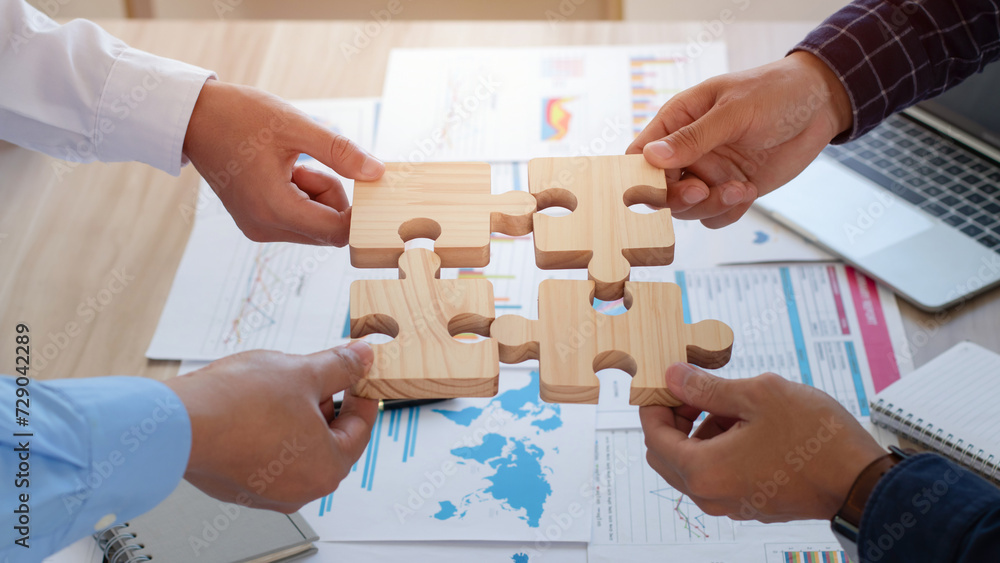 Concept of teamwork, cooperation and partnership. Business people connecting puzzle pieces in office. teamwork, Unity, volunteer, success and strategy.  Business idea by merging jigsaw puzzle. - obrazy, fototapety, plakaty 