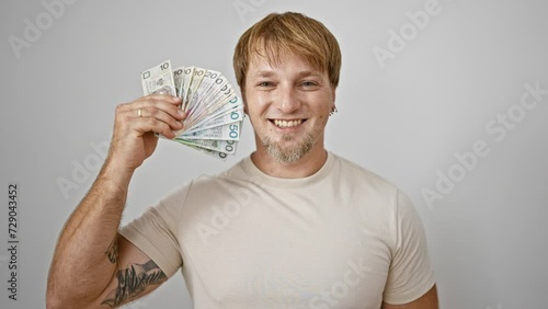 Blond man with beard smiling, holding polish zloty cash against a white background photo