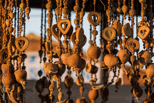 Photography different jewelry made of wood corals and shells hanging in a shop in the sun de