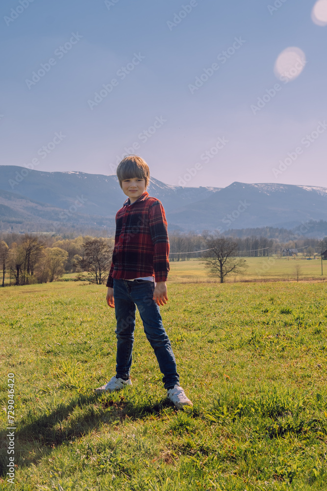 Smiling boy on the sun, mountains at the back