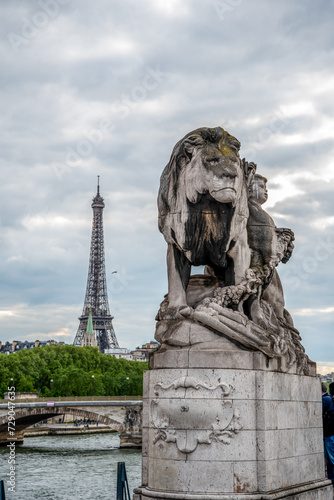 Statue of a Lioin on Bridge Alexandre III, view to Eiffel tower, Paris