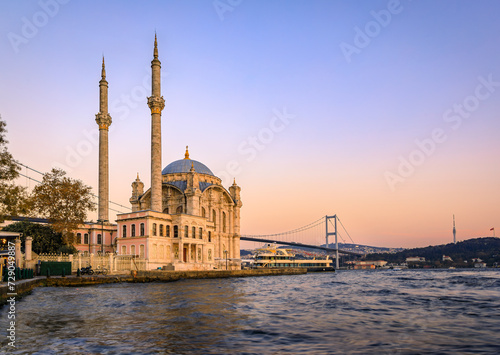 Picturesque cityscape with the Bosphorus Strait and the Grand Mecidiye Mosque Ortakoy Mosque and the Bosphorus Bridge Istanbul, Turkey at sunset photo