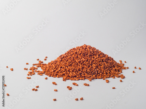 pearl gold masterbatch granules on a white background, this polymer is a product colorant for products in the plastics industry