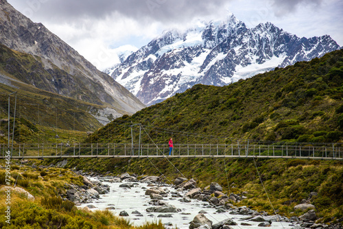 hiker girl walking alongside hooker valley track toward hooker lake and mt cook, famous walk in canterbury, new zealand south island photo