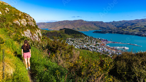 pretty hiker girl enjoying the panorama of lyttelton after finishing the hike on the bridle path from christchurch to lyttelton; beautiful view from gondola summit station, canterbury, new zealand 