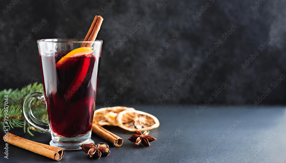 Mulled red wine with cinnamon, orange and spices with fir branches on the background Mulled red wine with cinnamon, orange and spices with fir branches on the background