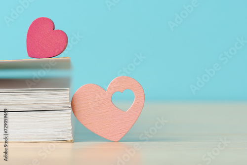 Two wooden hearts with book, symbolizing love and romance