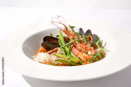 Tomato risotto with seafood on a white plate, perfect for Mediterranean cuisine and healthy eating concepts