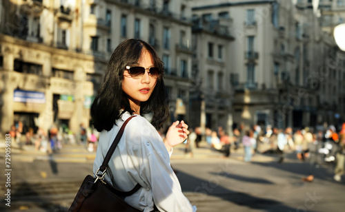 Outdoor  lifestyle portrait of attractive Asian woman wearing modern casual summer elegant outfit and leather on city street