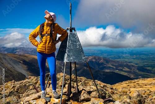 backpacker enjoying the stunning panorama of new zealand alps from the top of mount somers in canterbury photo