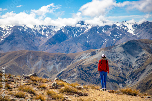 backpacker enjoying the stunning panorama of new zealand alps from the top of mount somers in canterbury