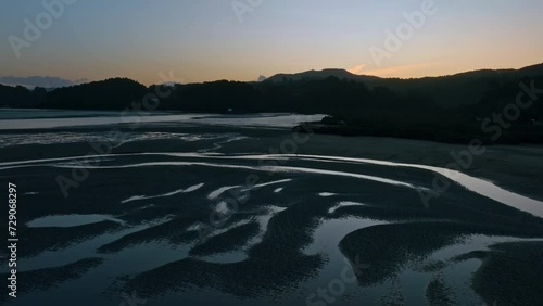 Aerial: Whangateau Harbour in low tide in sunset. Point Wells, near Warkworth, New Zealand photo