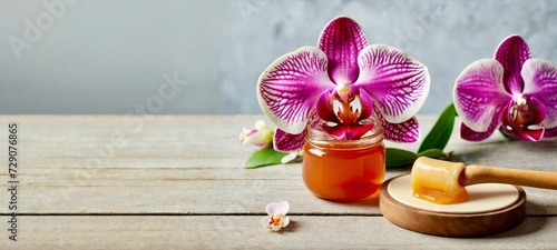 Sugar paste or wax honey for hair removing flows down from wooden waxing spatula sticks in jar with orchid flower  background copy space. Banner  Depilation and beauty concept. 
