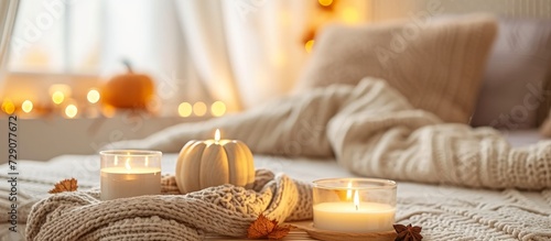 Fall-themed bedroom with cozy atmosphere, knitted sweater, candles, autumn scent diffuser, and pumpkin, cinnamon, and anise aromas. photo