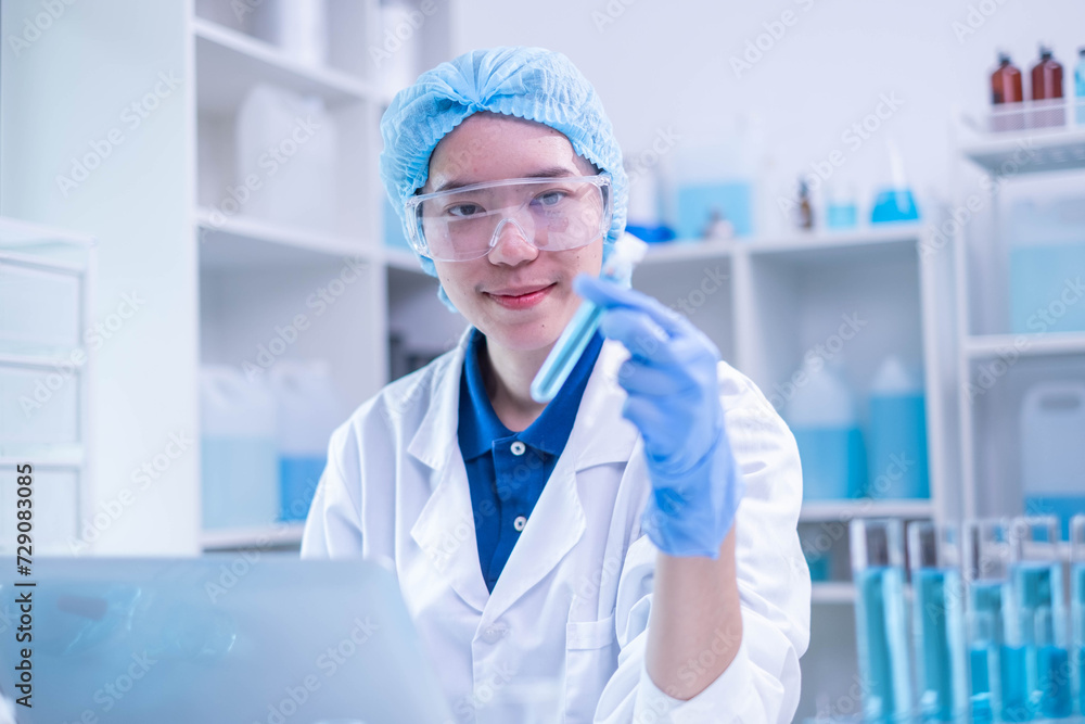 Closeup female woman scientist's hand holding blue liquid chemical chemistry test tube working in analyze science laboratory research experiment Closeup female woman scientist's hand holding blue liquid chemical chemistry test tube working in analyze science laboratory research experiment