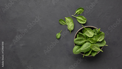 Fresh spinach leaves on black stone background. Copy space for menu or recipe. Flat Lay.