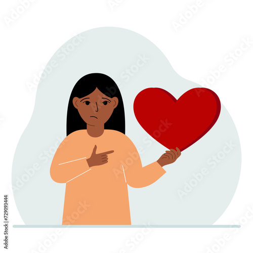 A girl holds a big red heart in his hand. The concept of volunteering, romantic relationship or love.