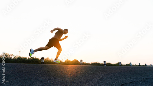 The man with runner on the street be running for exercise. Sport Backgrounds, Male runner ready for sports exercise, Athlete running on athletic track. Athlete runner feet running on road