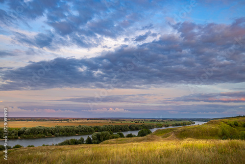 A breathtaking view of the endless expanses  the bend of the river against the backdrop of a colorful landscape and water meadows.