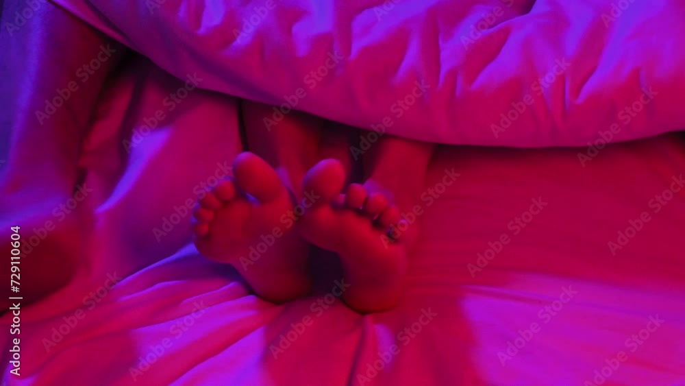 legs of a couple having hard sex under a blanket on a bed in the