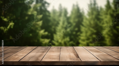 Empty wooden tabletop or terrace for product display with blurred green fir forest background behind. Copy space 