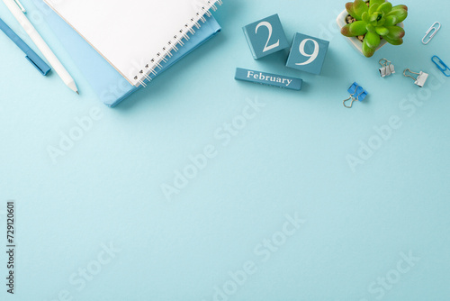 February's final workday captured: top-view photo with memo pads, pens, desk accessories, a small plant, and a date block for the 29th of February, on a gentle blue surface, leaving space for wording